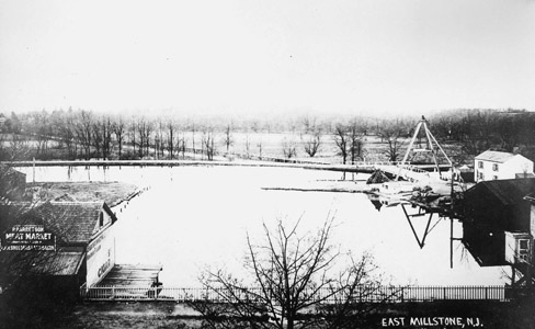 This photograph illustrates the East Millstone Basin denoted in the prior map image.  Many basins such as this one were once located along the Delaware and Raritan Canal.  When the canal was constructed, the community of what is now Millstone Borough found itself on the “wrong” (i.e. east) side of the Millstone River.  In order to ship agricultural products on the canal, a new commercial center called Johnsville developed up on the west side of the river.  Johnsville was incorporated as East Millstone Borough in 1873, and became part of Franklin Township in 1949.  The photograph shows Bridge No. 21, along with the bridgetender’s house which survives (albeit precariously close to Amwell Road) to this day.  The site of the basin is now occupied by the East Millstone First Aid Squad building and a playing field. (Photograph Courtesy of the Franklin Township Library)